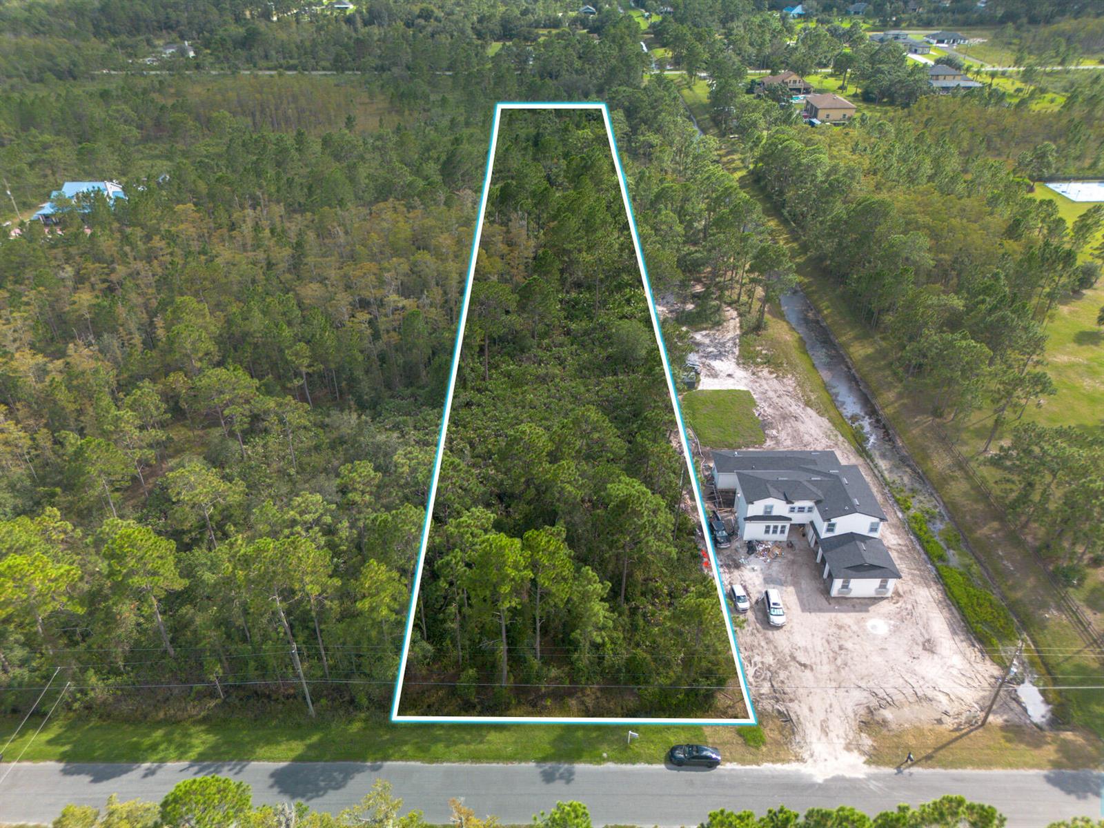 An aerial view shows a trapezoidal wooded lot outlined in blue next to a house — 0 Sabal Street, Orlando FL 32833, ORLANDO, FL