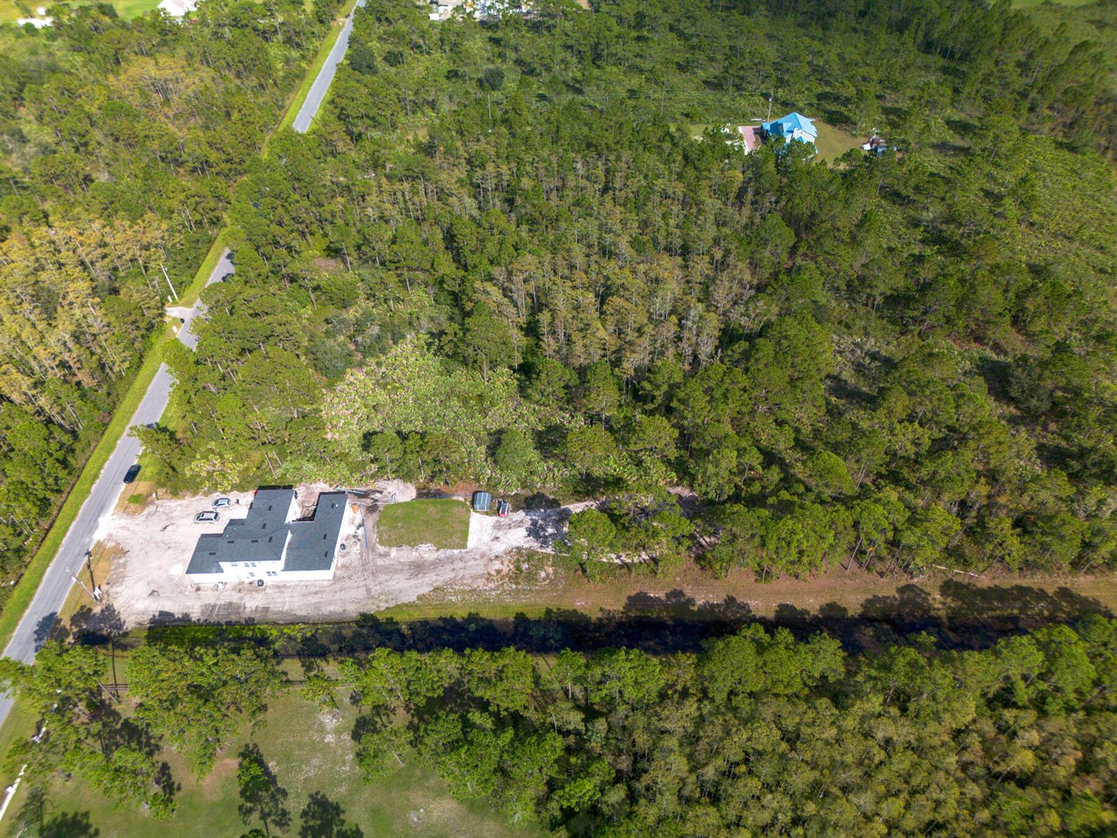 An aerial view shows a newly constructed house on a large, wooded lot with a canal — 0 Sabal Street, Orlando FL 32833, ORLANDO, FL