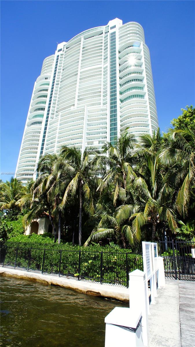 A tall white residential high-rise building stands behind a row of palm trees and water — 1643 Brickell Slip #5, Miami FL 33129, MIAMI, FL