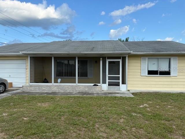A single-story house with yellow siding, a screened-in front porch, and an attached garage — 499 WATER ROAD, OCALA, FL