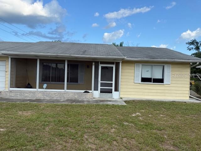 A single-story yellow house features a screened-in front porch and a white front door — 499 WATER ROAD, OCALA, FL