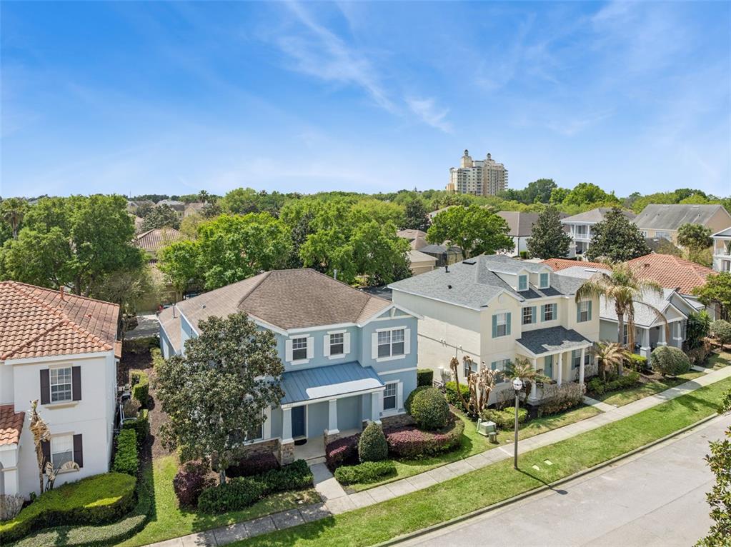 An aerial view shows several suburban houses with landscaped yards and trees under a blue sky — 7412 DEVEREAUX STREET, KISSIMMEE, FL