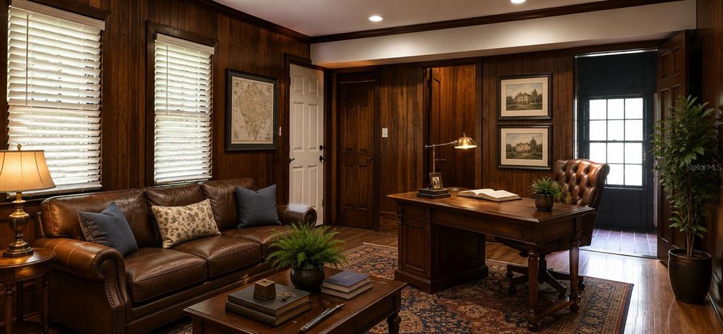 A wood-paneled office features a leather sofa, a wooden desk, and a patterned area rug — 18406 HIGH SPRINGS MAIN STREET, HIGH SPRINGS, FL