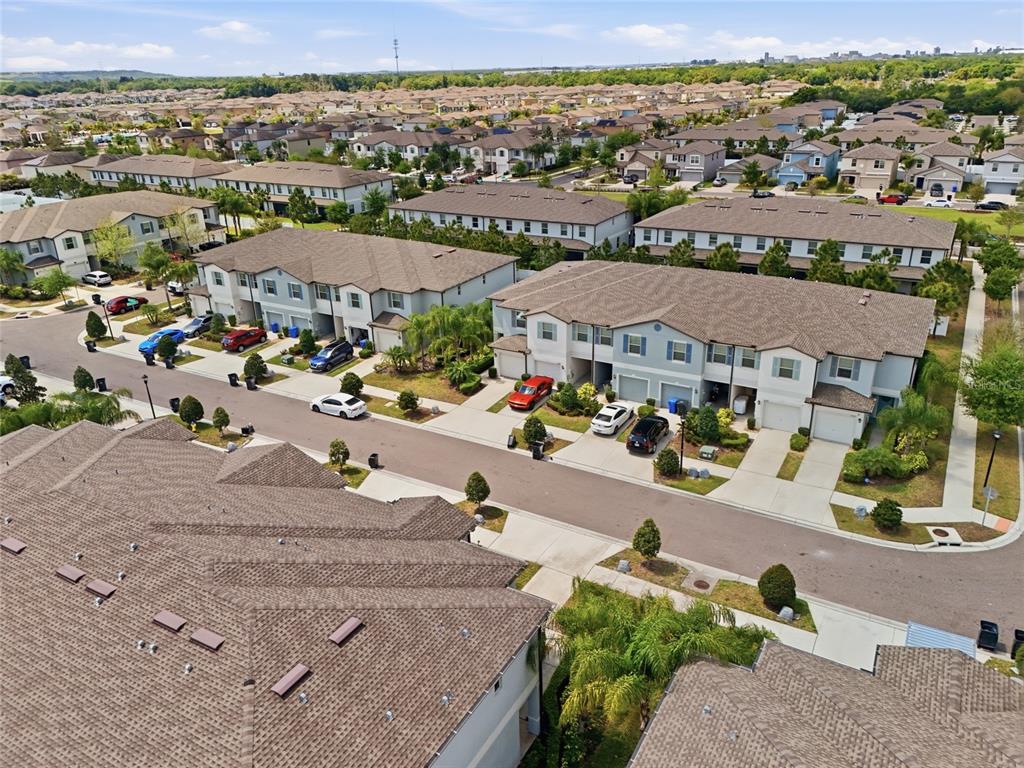 An aerial view shows several multi-story townhome buildings with attached garages and parked cars — 4540 GLOBE THISTLE DRIVE, TAMPA, FL