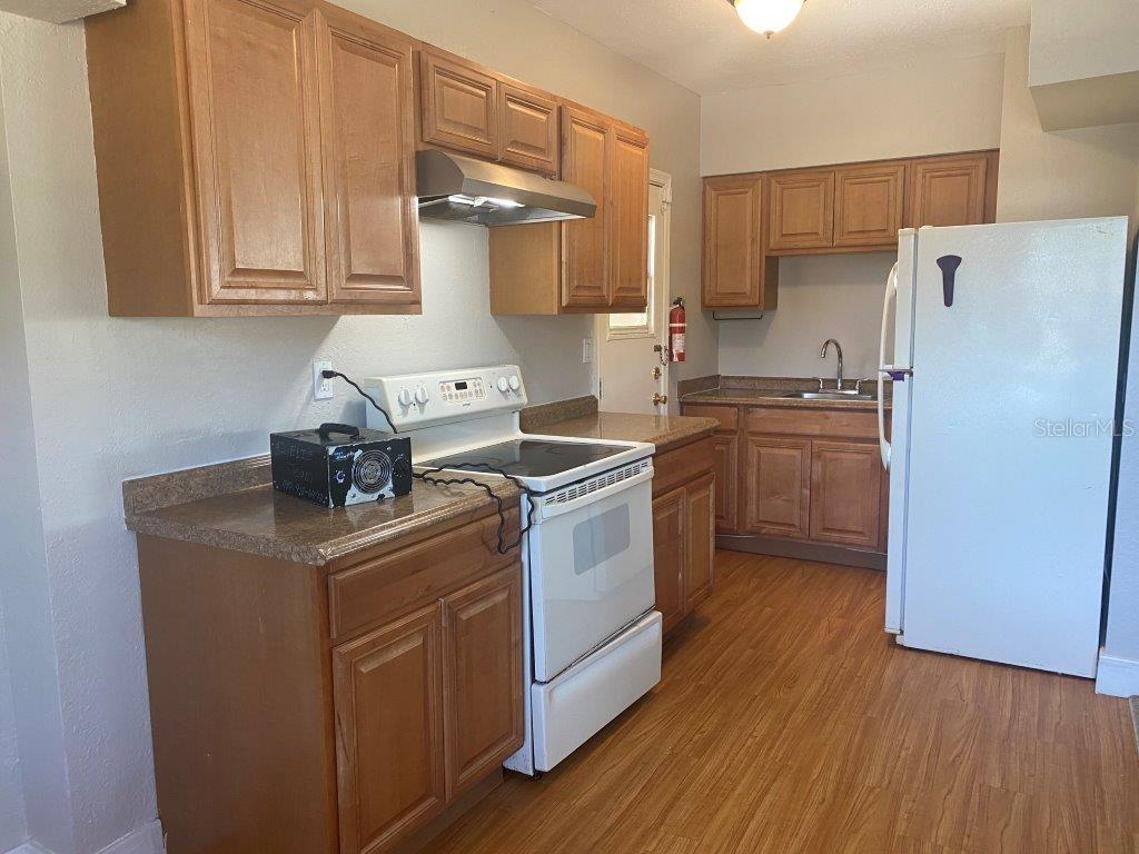 A kitchen features wood cabinets, laminate countertops, a white stove, and a white refrigerator — 741 W OSCEOLA STREET, CLERMONT, FL