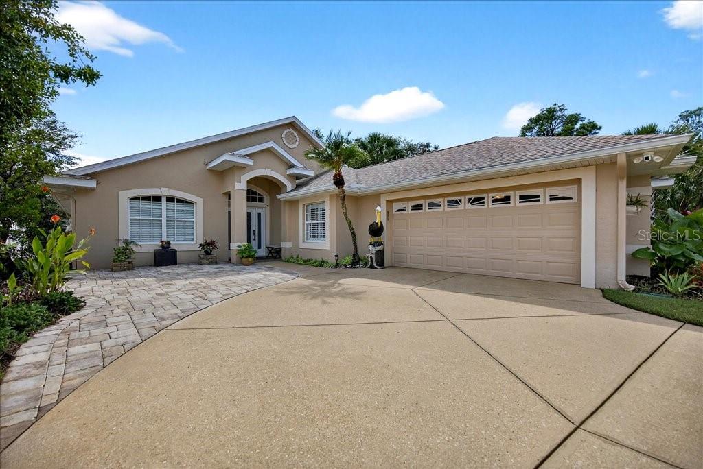 A beige single-story house features a paved driveway, a two-car garage, and a covered entryway — 83 COVINGTON LANE, PALM COAST, FL