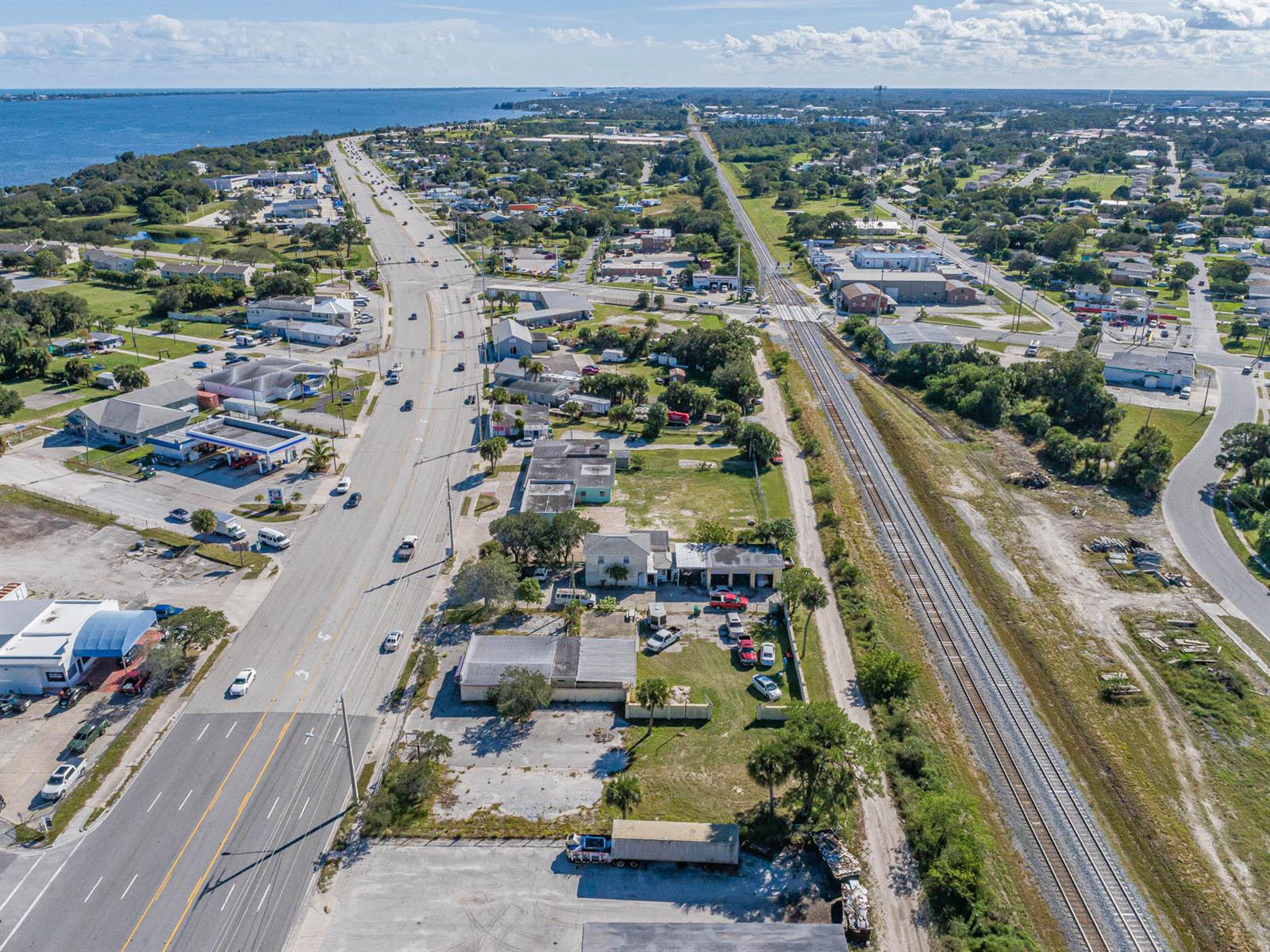 An aerial view shows a multi-lane road, railroad tracks, and surrounding commercial and residential buildings — 2814 S Harbor City Boulevard, Melbourne FL 32901, MELBOURNE, FL