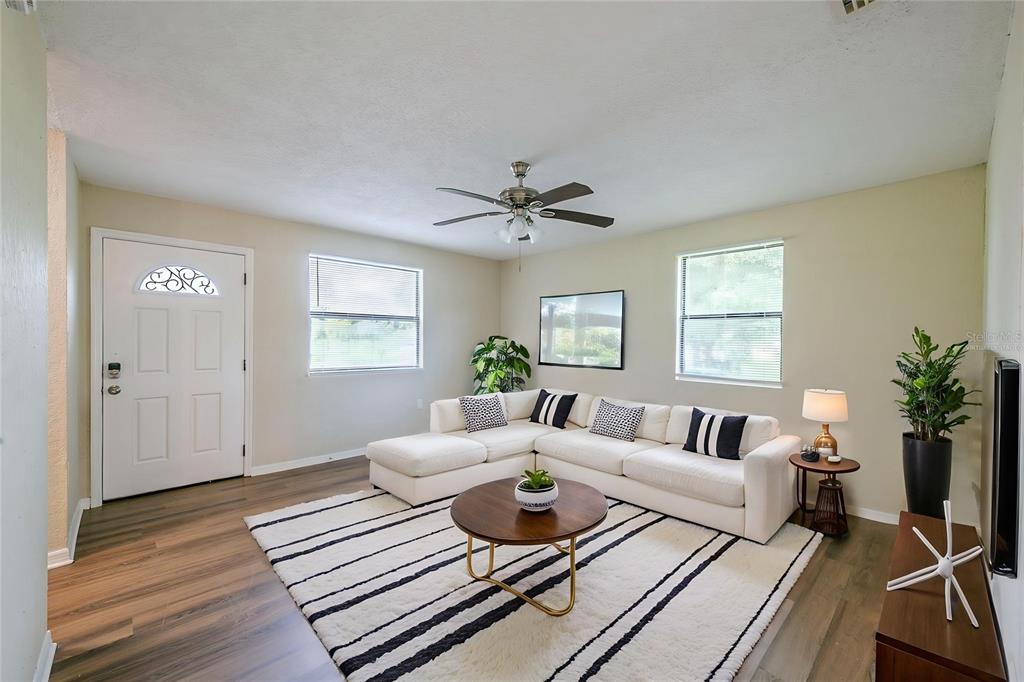 A living room features a white sectional sofa, a round coffee table, and striped rug — 523 CARVER BOULEVARD, ORLANDO, FL