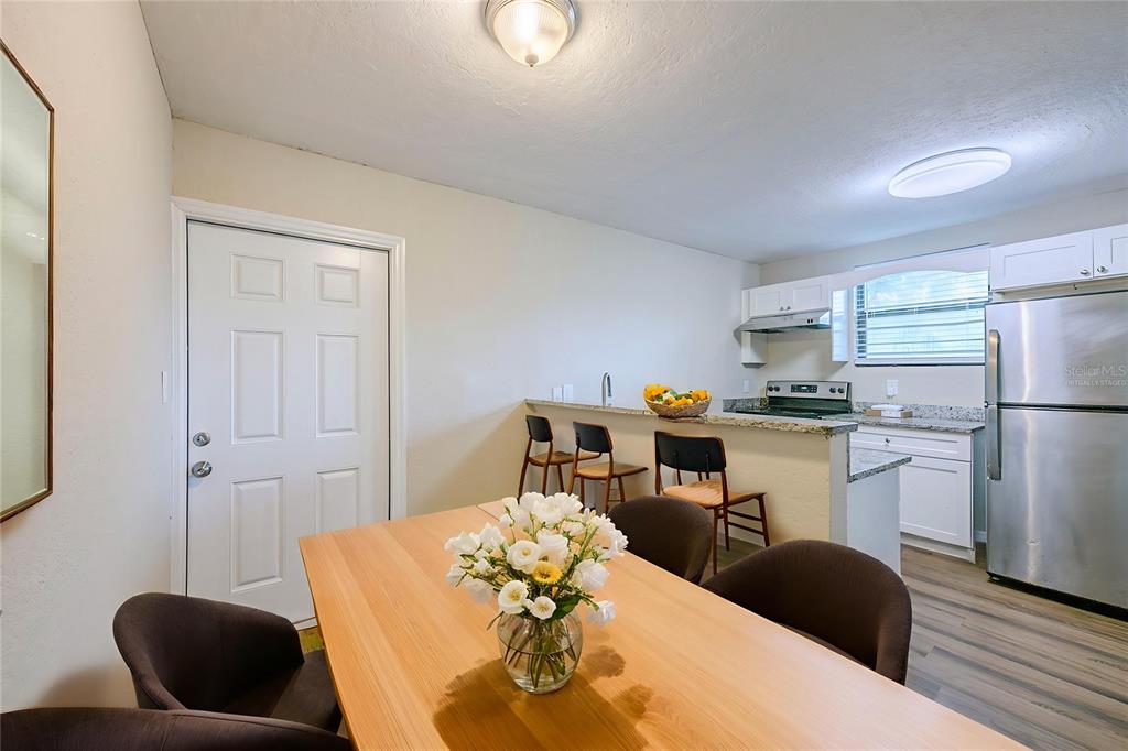 A dining area with a wooden table and chairs sits adjacent to a kitchen counter — 523 CARVER BOULEVARD, ORLANDO, FL