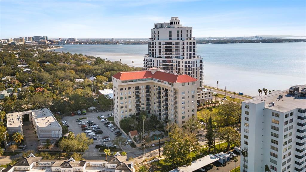 A kitchen features stainless steel appliances, white cabinetry, and a granite-topped breakfast bar — 2109 BAYSHORE BOULEVARD UNIT 205, TAMPA, FL