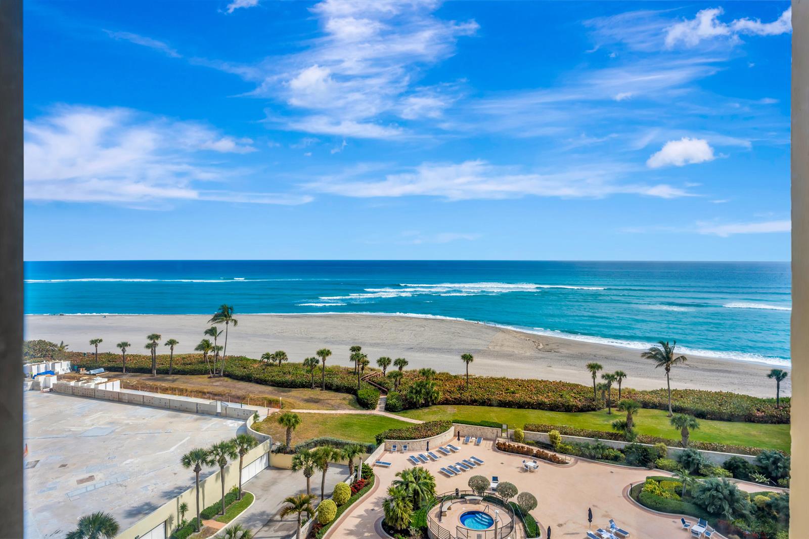 An elevated view of a beach, ocean, and a pool deck with palm trees — 300 Ocean Trail Way # 1008, Jupiter FL 33477, JUPITER, FL