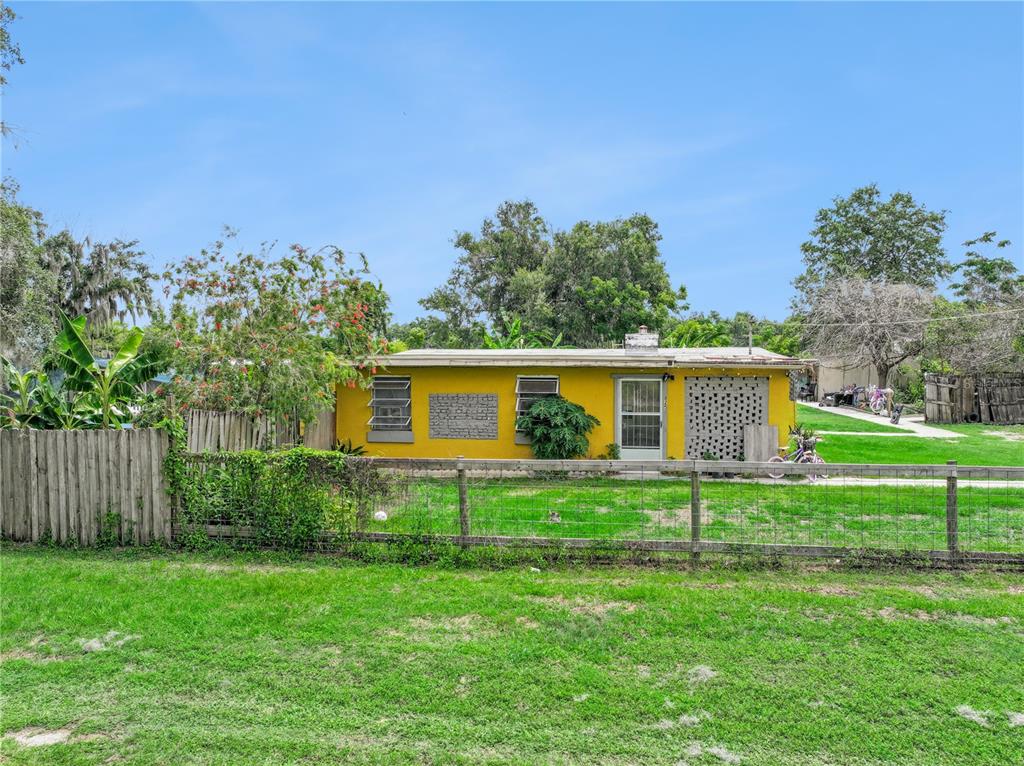 A yellow single-story house with a fenced yard and a screen door — 825 COOK ROAD, MULBERRY, FL