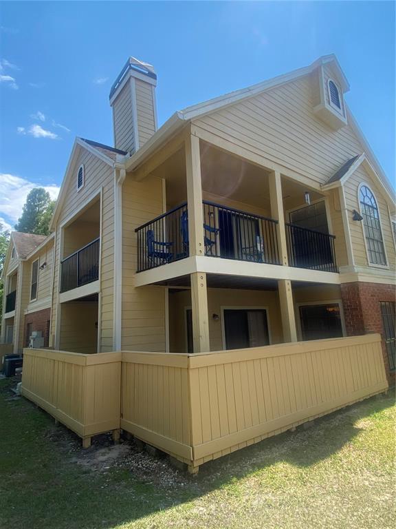 A two-story apartment building with yellow siding, a brick base, and private balconies — 8724 MALLARD RESERVE DRIVE UNIT 102, TAMPA, FL