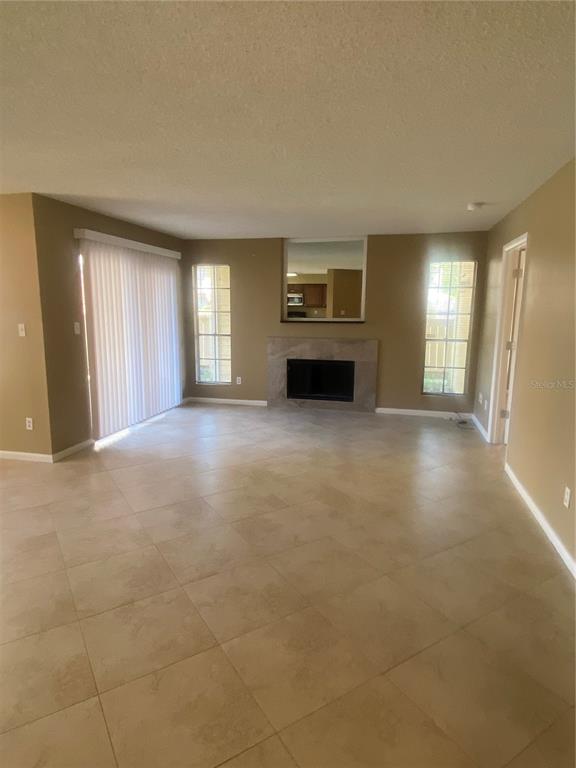 A living room features beige tile flooring, a fireplace, and a sliding glass door — 8724 MALLARD RESERVE DRIVE UNIT 102, TAMPA, FL