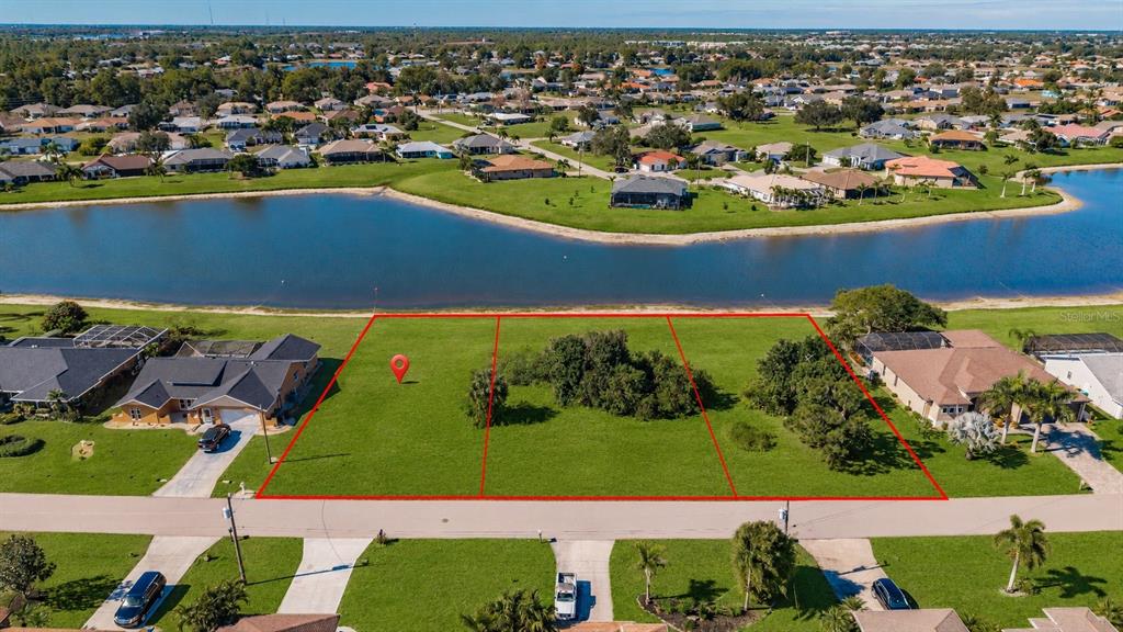 An aerial view shows three vacant waterfront lots outlined in red along a residential street — 2377 SOFIA LANE, PUNTA GORDA, FL