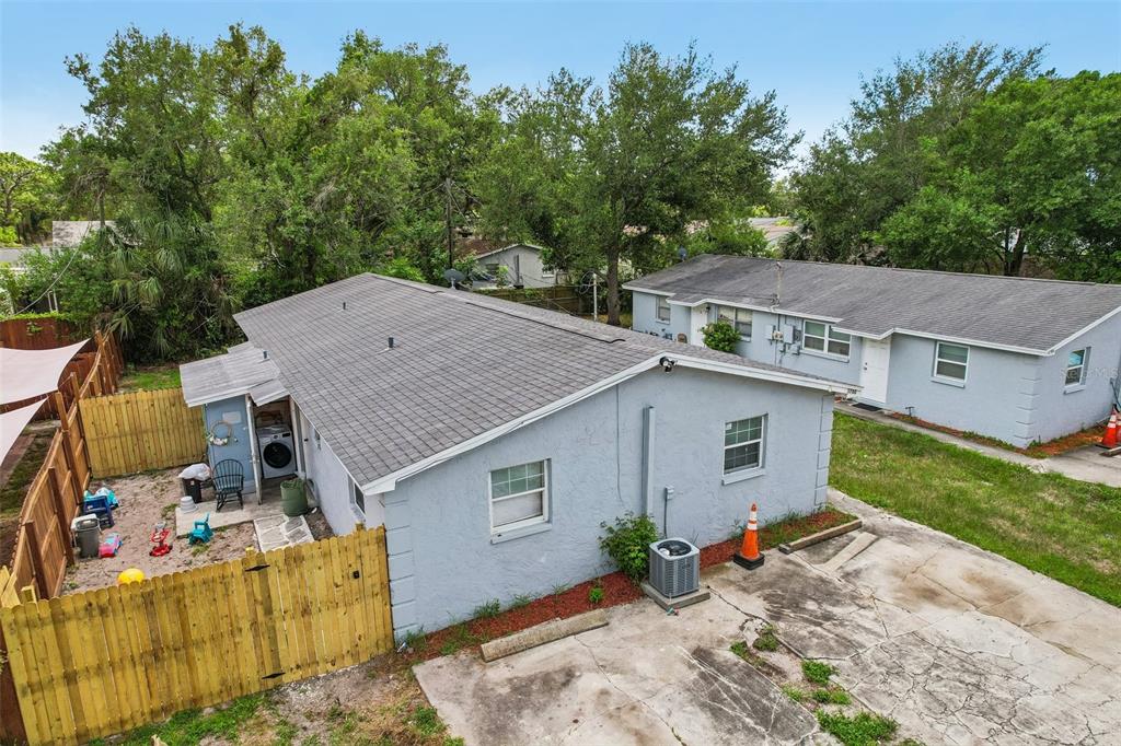 An elevated exterior view of a light blue house with a gray shingled roof — 3780 137TH AVENUE, LARGO, FL
