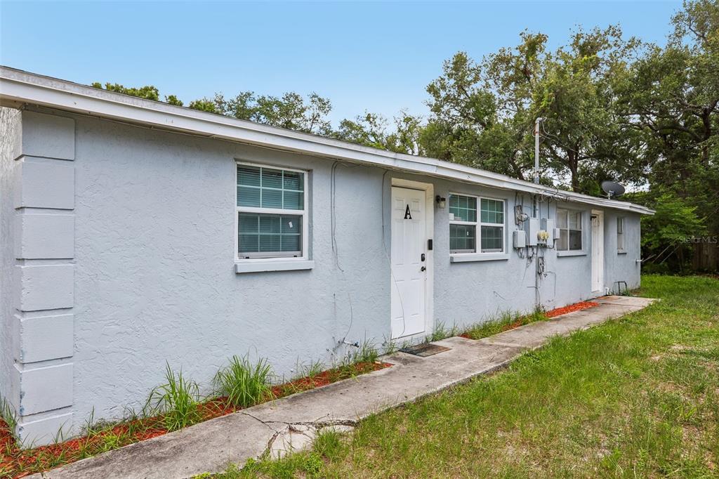 The exterior of a light blue single-story building with a concrete walkway and two doors — 3780 137TH AVENUE, LARGO, FL
