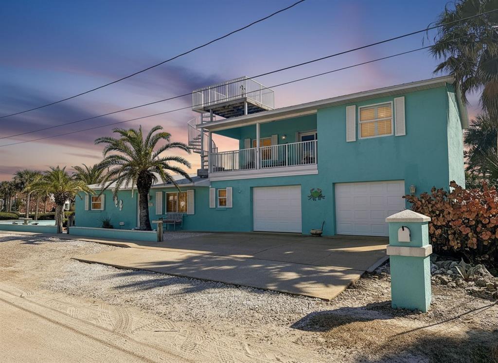 A two-story teal house with a rooftop deck, spiral staircase, and two garage doors — 923 LOCUST STREET, NEW SMYRNA BEACH, FL