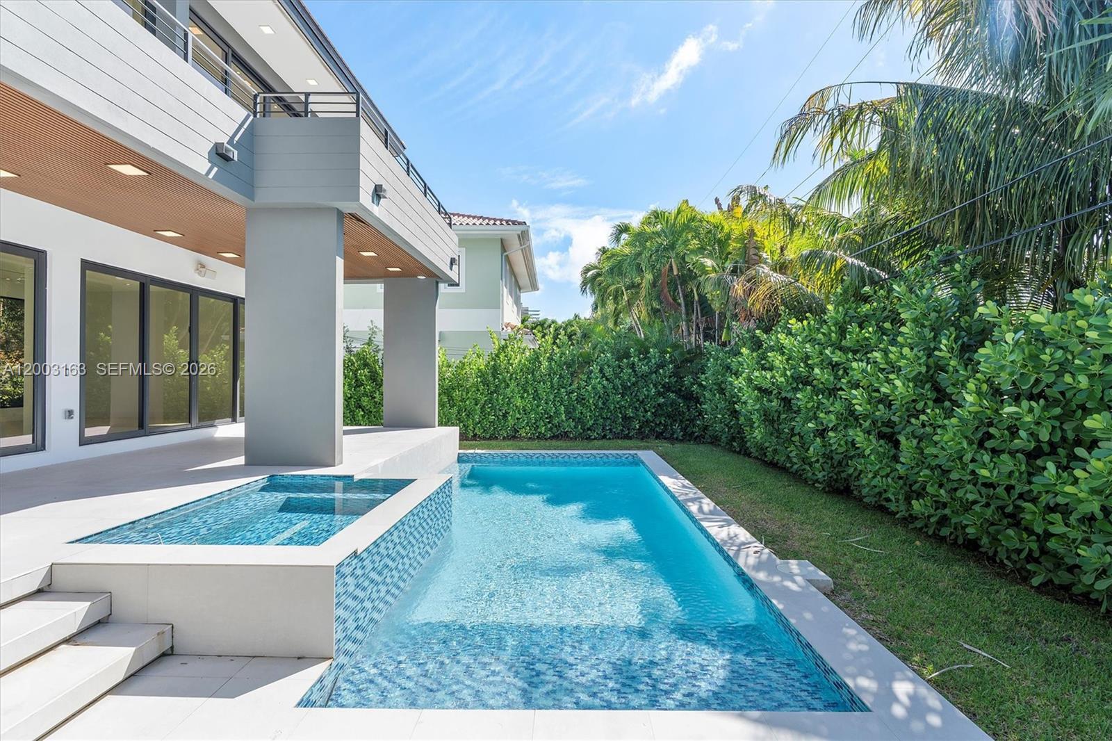 A modern house features a patio with a pool and an attached spa — 760 Woodcrest Rd, Key Biscayne FL 33149, KEY BISCAYNE, FL