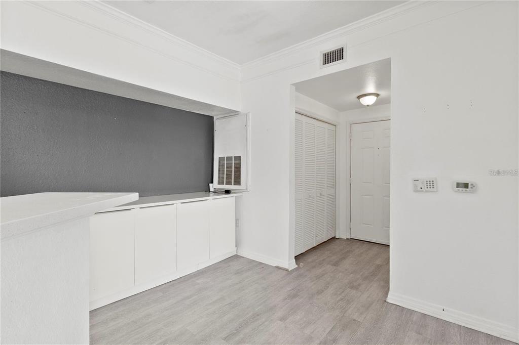 A room with white walls, gray flooring, built-in cabinets, and a doorway leading to an entryway — 3428 SOHO STREET UNIT B08, ORLANDO, FL