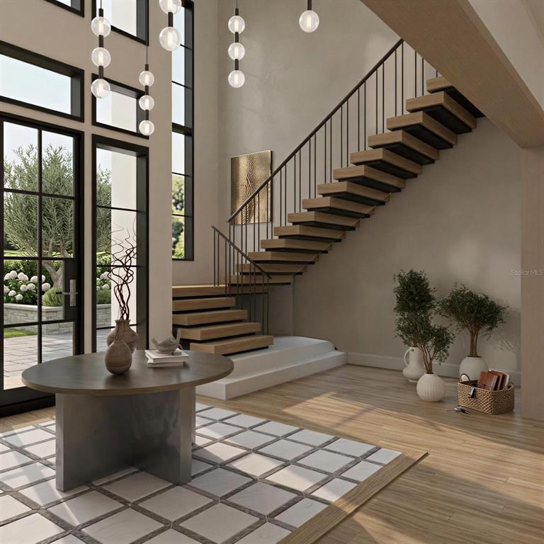 This rendering shows a modern entryway with a floating staircase, large windows, and a round table — 9108 SHEEN SOUND STREET, ORLANDO, FL