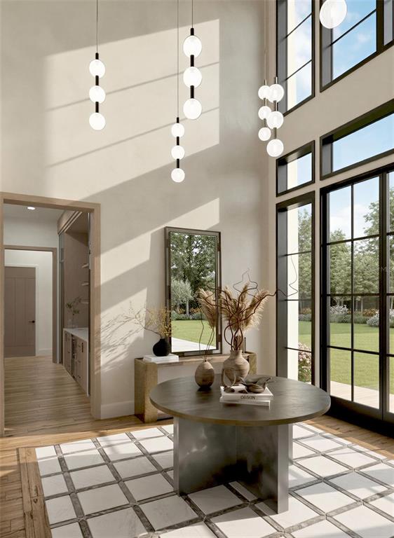 This rendering shows a high-ceilinged entryway with a round table, pendant lights, and large windows — 9108 SHEEN SOUND STREET, ORLANDO, FL