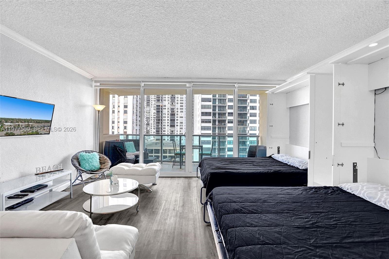 A studio apartment features two beds, a living area, and a balcony with city views — 2501 S Ocean Dr, Hollywood FL 33019, HOLLYWOOD, FL