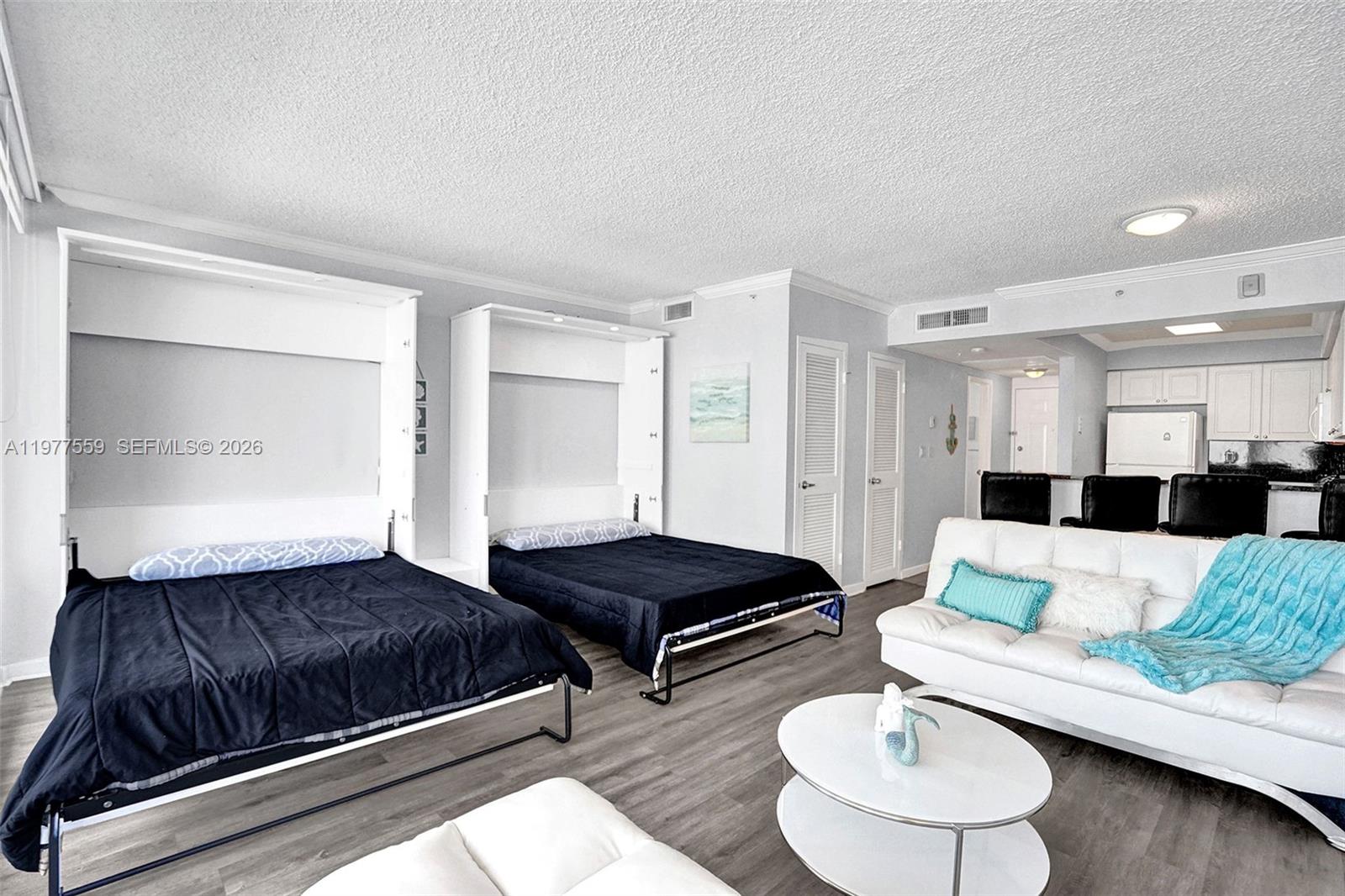 A studio apartment features two wall beds, a white sofa, and an open kitchen — 2501 S Ocean Dr, Hollywood FL 33019, HOLLYWOOD, FL