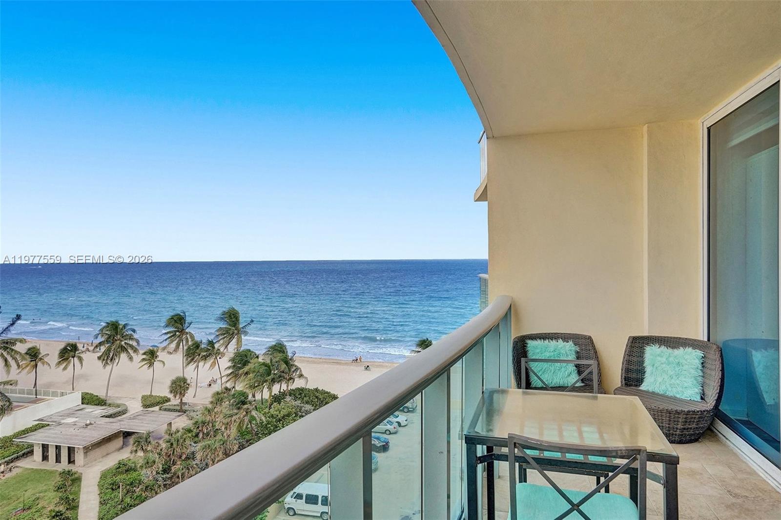 A balcony with a glass railing overlooks a sandy beach and the ocean — 2501 S Ocean Dr, Hollywood FL 33019, HOLLYWOOD, FL