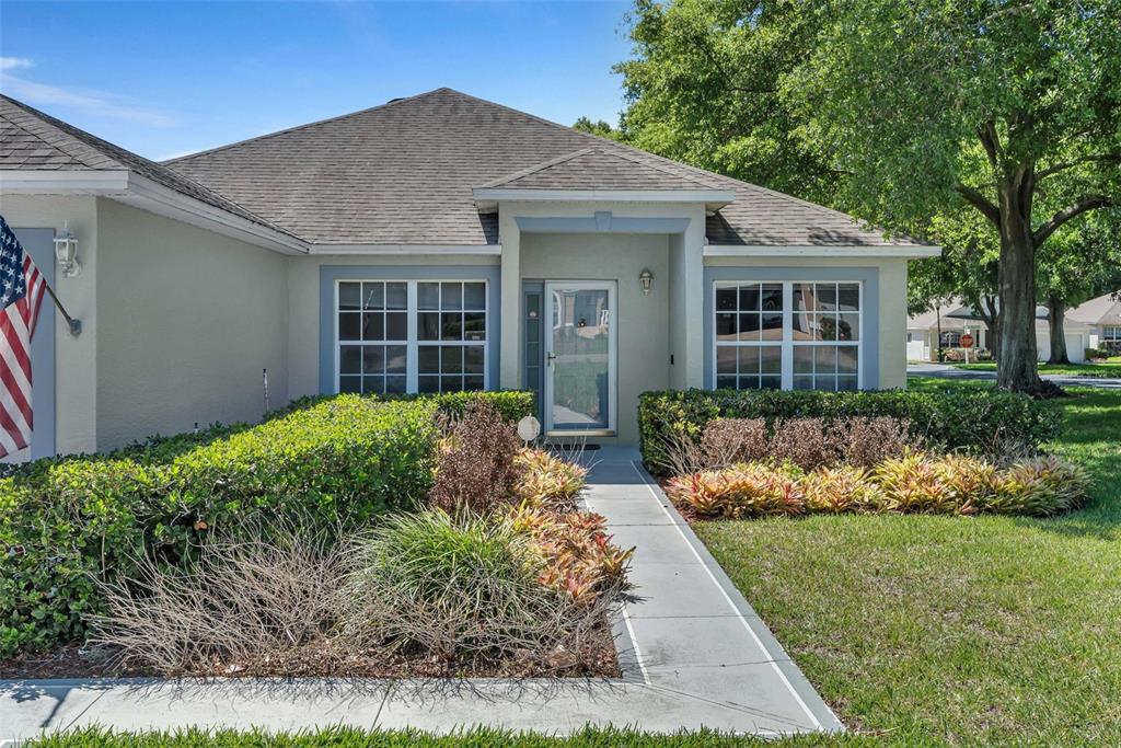 A single-story house exterior features a front walkway, landscaping, and a covered entryway — 3871 EVERSHOLT STREET, CLERMONT, FL