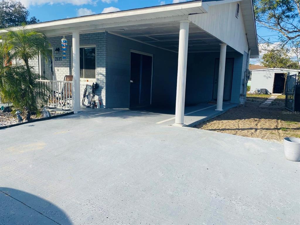 A single-story house with a gray painted brick exterior and an attached carport — 2337 LAURA STREET, LAKE WALES, FL