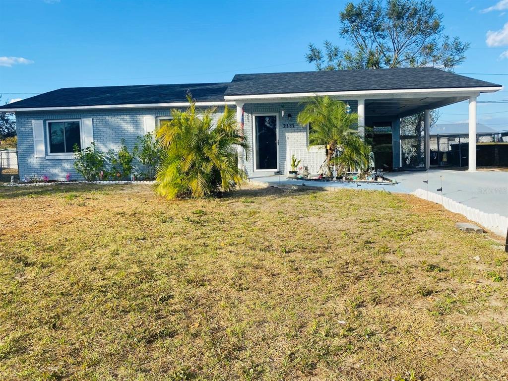 A single-story house with a light blue brick exterior and an attached carport — 2337 LAURA STREET, LAKE WALES, FL