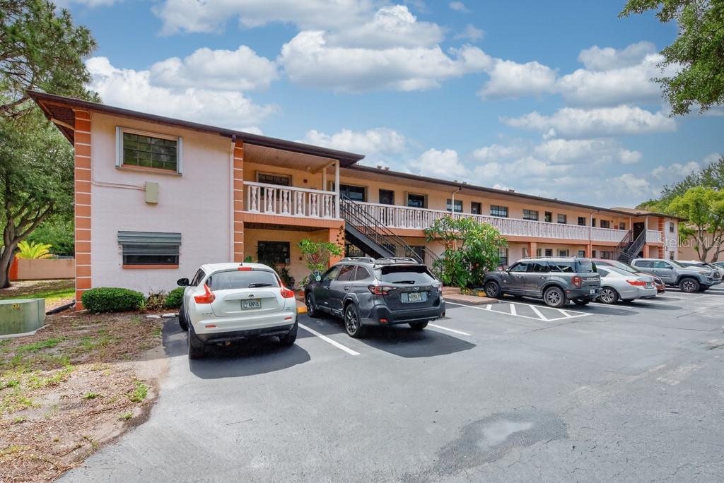 A two-story apartment building with a parking lot in front under a cloudy sky — 13250 RIDGE ROAD UNIT 3B3, LARGO, FL