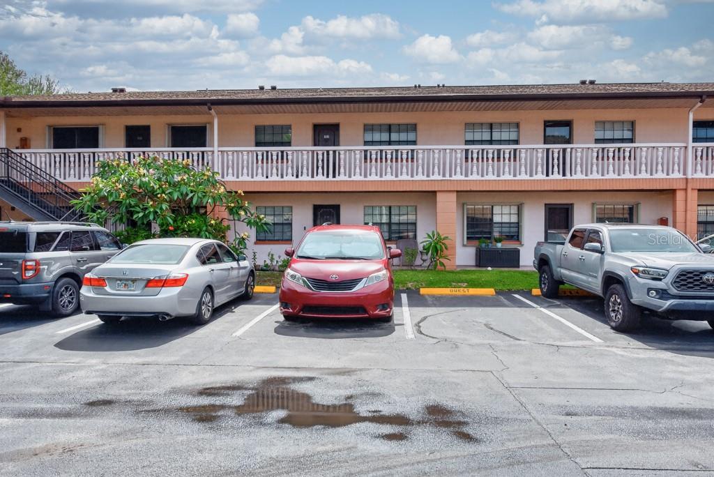 A two-story apartment building exterior with a parking lot in the foreground — 13250 RIDGE ROAD UNIT 3B3, LARGO, FL