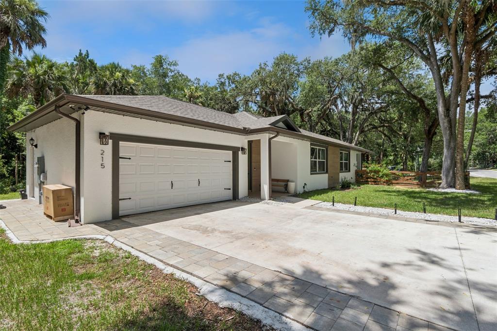 A white single-story house with a two-car garage and a paved driveway — 215 SUNRISE BOULEVARD, DEBARY, FL