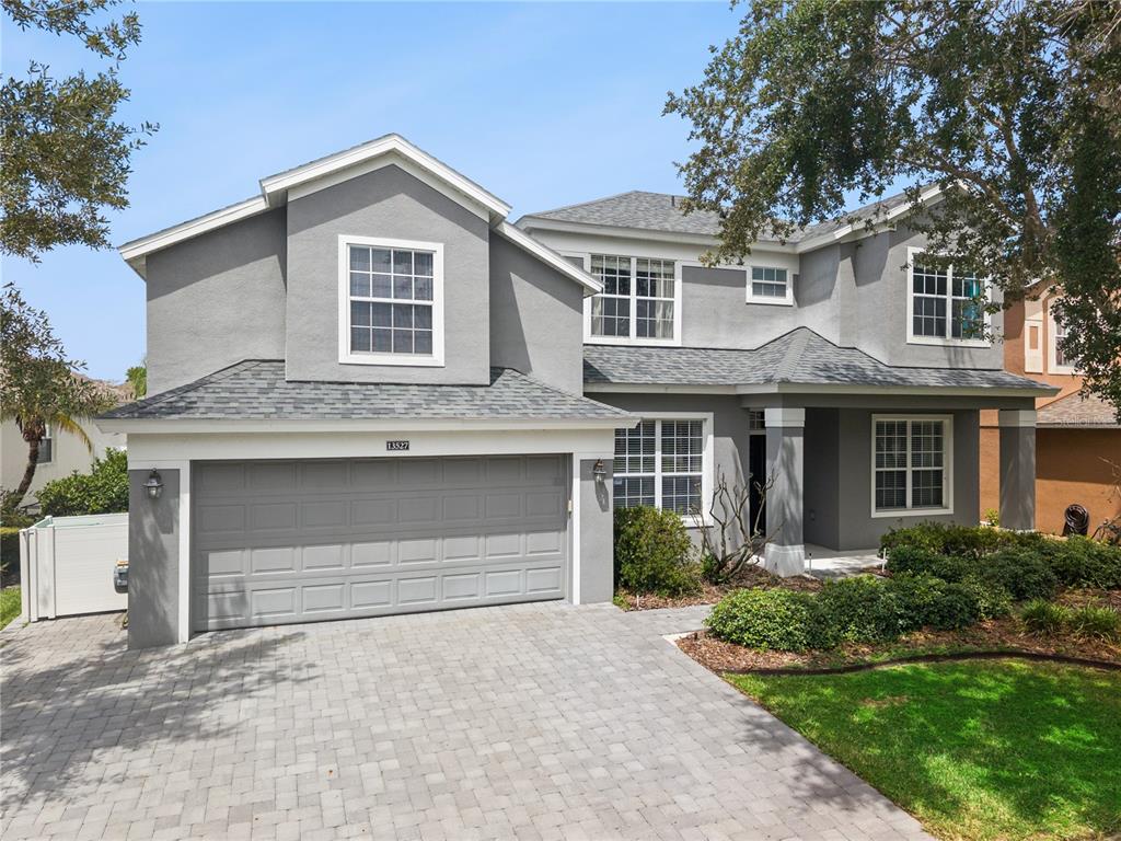 A two-story gray house with a two-car garage and a paved driveway — 13527 FOX GLOVE STREET, WINTER GARDEN, FL