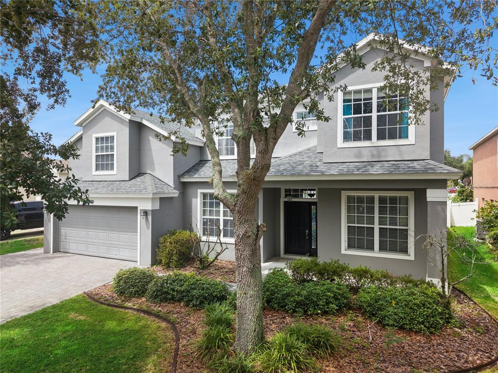 A two-story gray house with a two-car garage, a front porch, and a large tree — 13527 FOX GLOVE STREET, WINTER GARDEN, FL