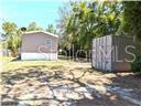 A mobile home stands next to a metal storage container on a grassy lot — 5416 W COUGAR LANE, DUNNELLON, FL