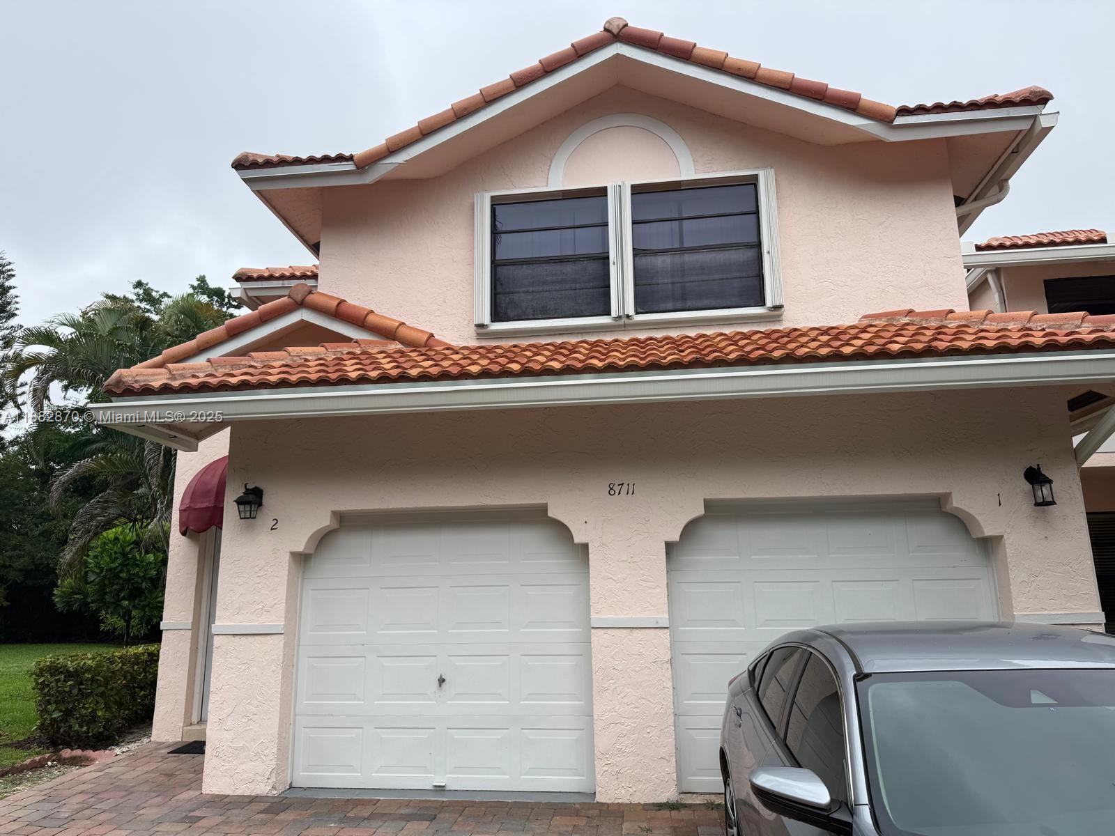 A two-story pink stucco house features a double garage and a terracotta tile roof — 8711 Via Giula # 2, Boca Raton FL 33496, BOCA RATON, FL