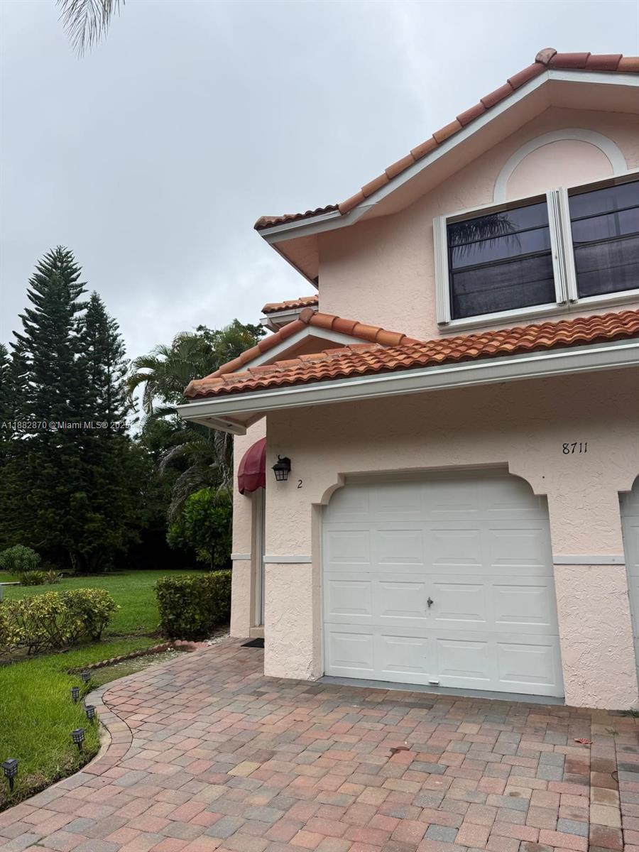 A two-story residential building features a tan stucco exterior, a garage, and a brick driveway — 8711 Via Giula # 2, Boca Raton FL 33496, BOCA RATON, FL