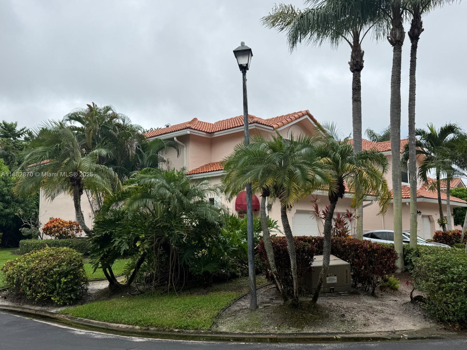 A two-story pink stucco house with a tile roof and palm trees in the front — 8711 Via Giula # 2, Boca Raton FL 33496, BOCA RATON, FL