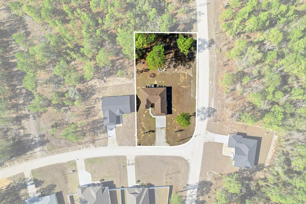 An aerial view shows a single-family home situated on a lot with trees — 15417 COOT ROAD, BROOKSVILLE, FL