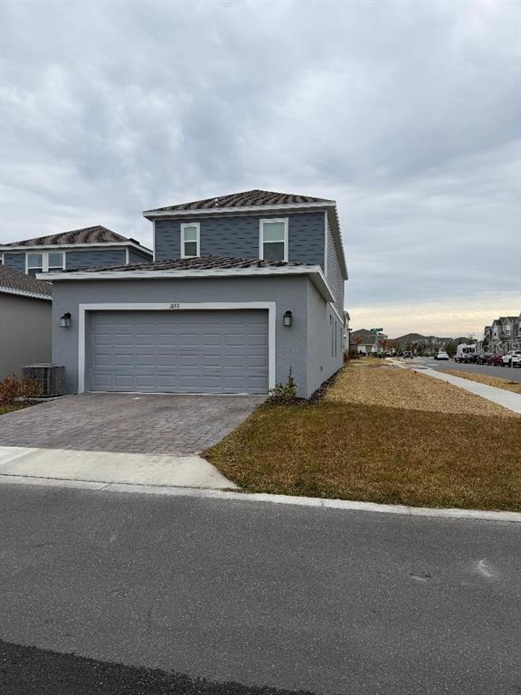 A two-story house with a gray stucco exterior, a two-car garage, and a paved driveway — 1892 BRIGHT SKY DRIVE, KISSIMMEE, FL