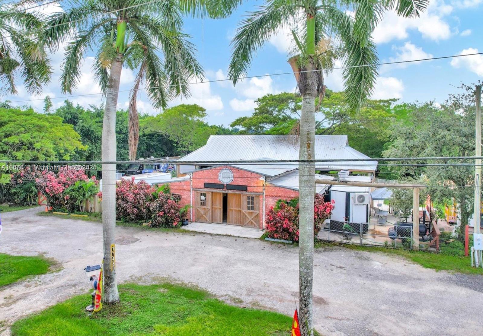 A red brick building with a metal roof sits behind two palm trees — 17480 SW 232nd St, Miami FL 33170, MIAMI, FL