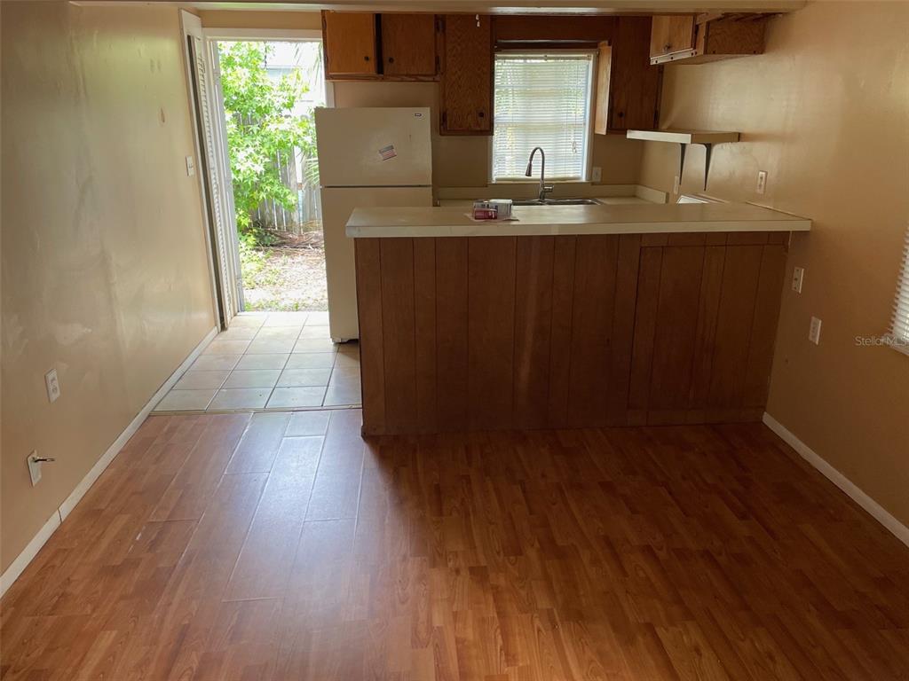 A kitchen features wood cabinets, a breakfast bar, and a door leading to the outdoors — 1661 27TH AVENUE N, ST PETERSBURG, FL
