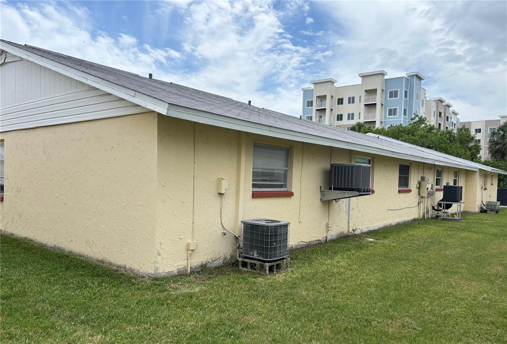 The exterior of a single-story yellow building features multiple air conditioning units and windows — 4923 GETNER STREET, NEW PORT RICHEY, FL