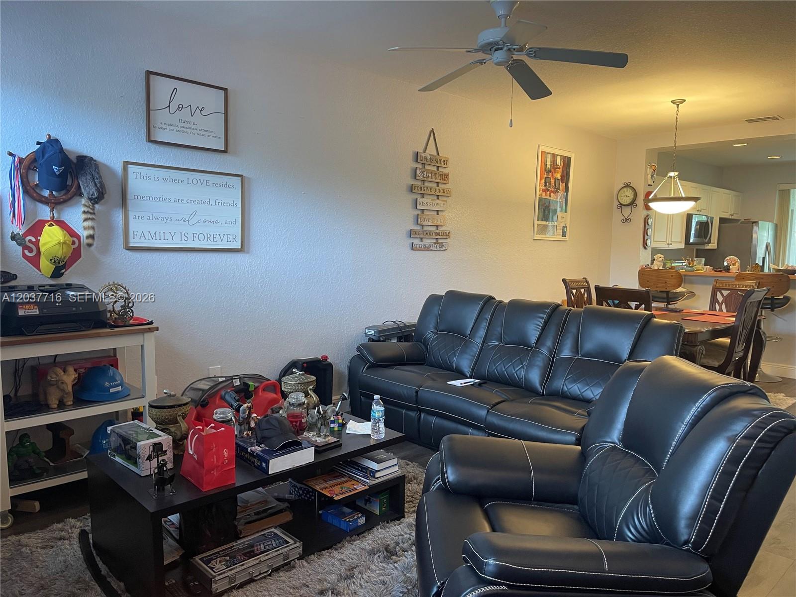 A living room features black leather furniture, a coffee table, and wall decor — 741 NW 42nd Ave, Plantation FL 33317, PLANTATION, FL