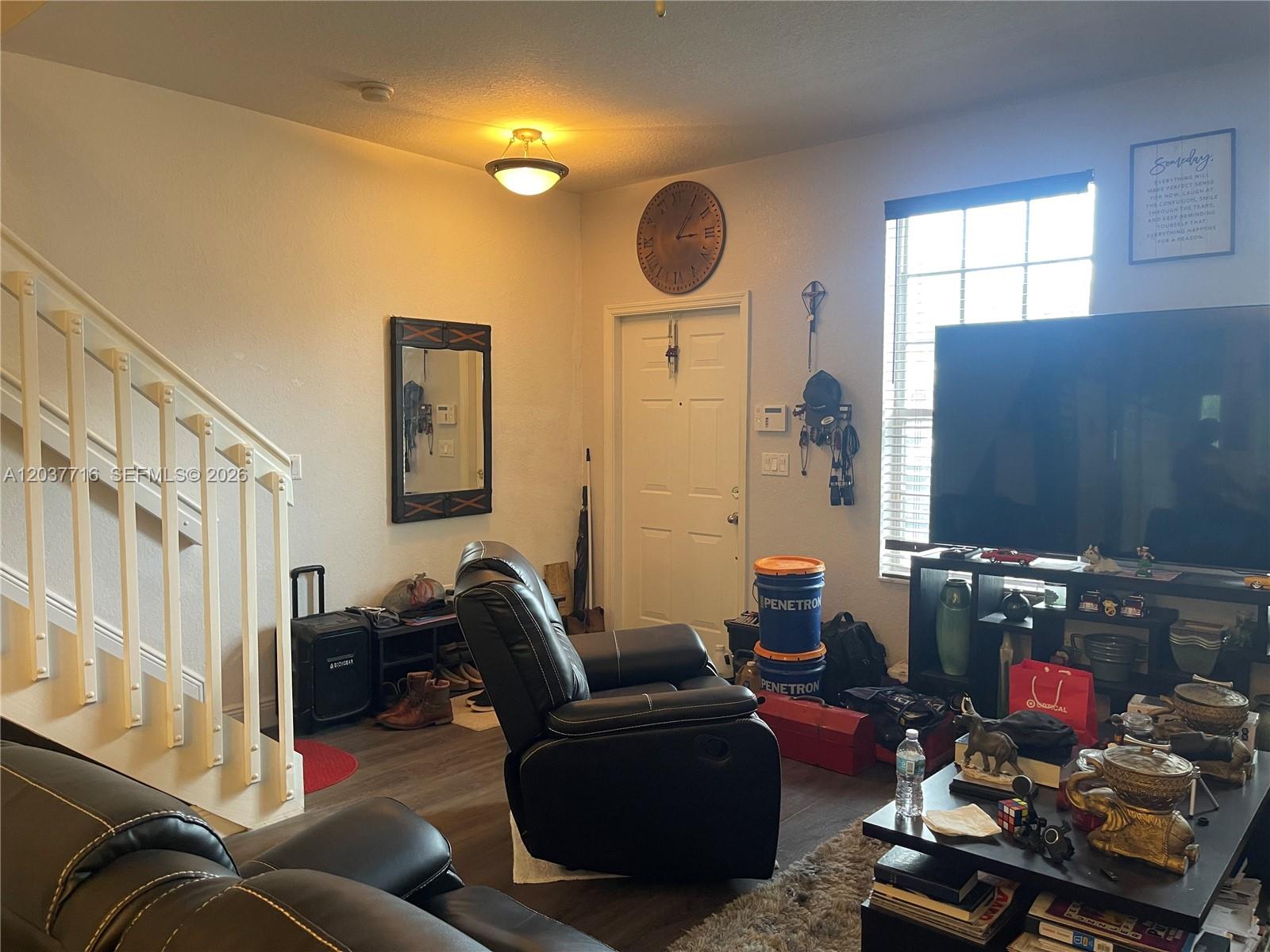 A living room features a staircase, a recliner, a television, and a front door — 741 NW 42nd Ave, Plantation FL 33317, PLANTATION, FL