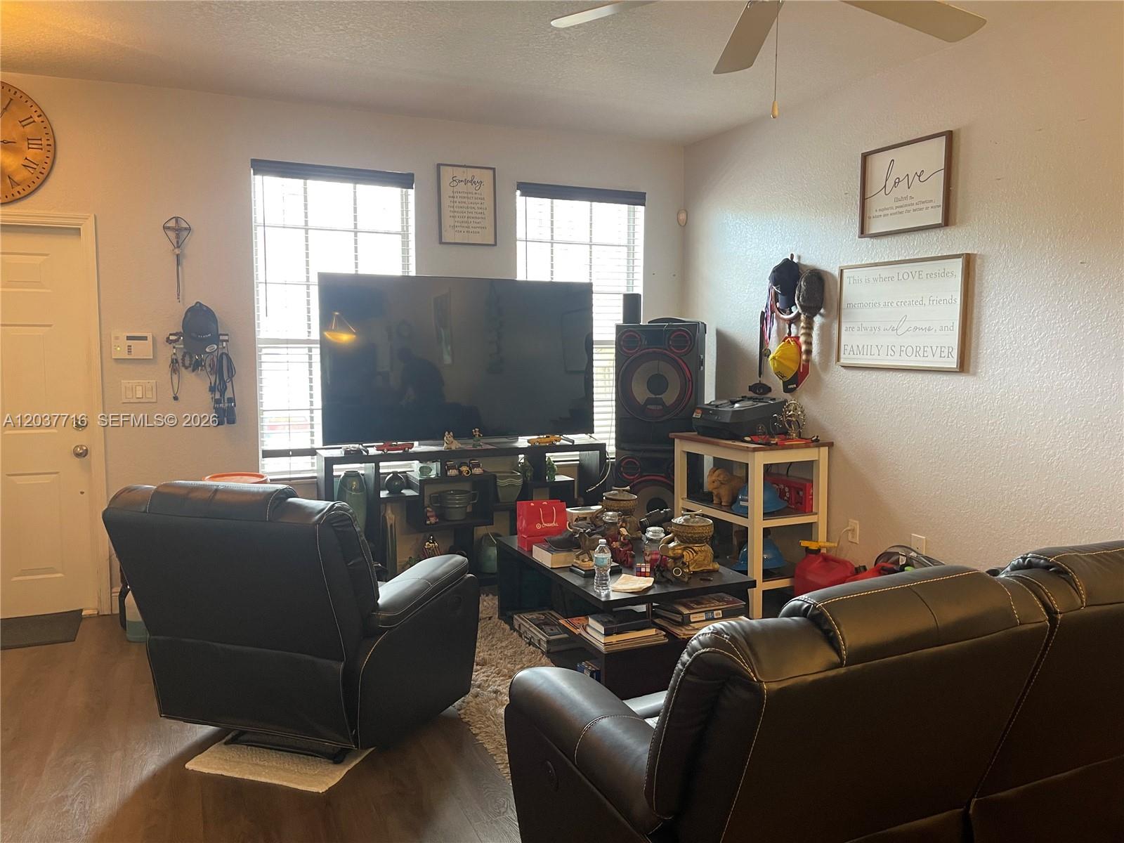 A living room features a large television, black leather furniture, and wall-mounted decor — 741 NW 42nd Ave, Plantation FL 33317, PLANTATION, FL
