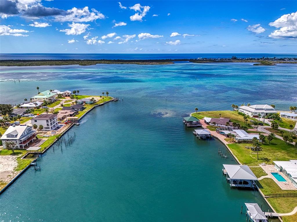 An aerial view shows a narrow canal leading into a bay with waterfront houses — 1962 ARKANSAS AVENUE, ENGLEWOOD, FL